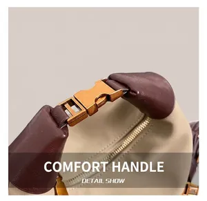 Détail d'une poignée en cuir marron avec boucle en métal doré et texture en toile