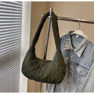 Detailed view of dark olive green quilted shoulder bag with classic rhombus pattern
