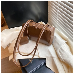 Detail of dark brown faux leather boston bag with a matching mini zipper pouch