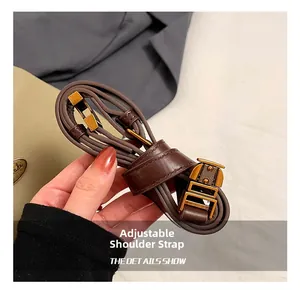Détail de la bandoulière réglable en cuir marron foncé avec boucle en métal doré vintage