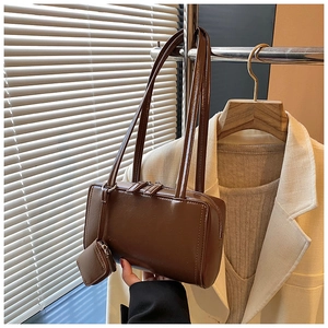 Detail of a dark brown PU leather rectangular shoulder bag with slim straps and a mini pouch