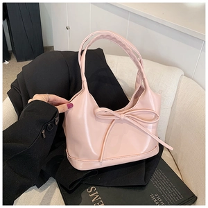 Détail du sac hobo rose en similicuir lisse avec décoration de nœud assorti