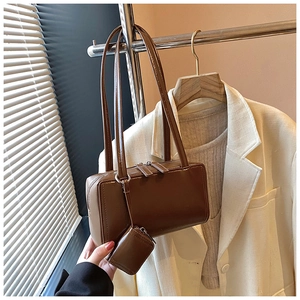 Close-up of vintage brown leather pillow bag with dual metal zippers and coin purse detail