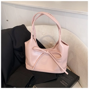 Détail d'un sac à main en cuir PU rose clair orné d'un nœud décoratif élégant