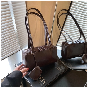 Detailed view of vintage dark brown faux leather pillow bag with double zippers and mini pouch