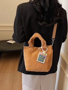 Brown fluffy faux fur bucket bag with colorful calculator charm and shoulder strap