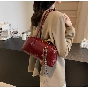 Detailed view of a dark red glossy bowling bag with gold lettering on a cafe background