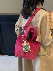 Fuchsia plush tote bag with a yellow calculator charm and detachable shoulder strap