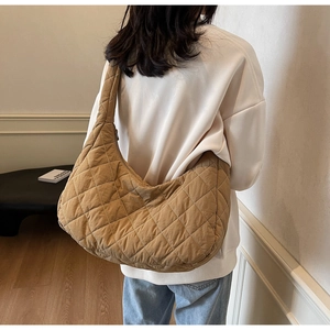 Close-up of quilted caramel shoulder bag with diamond stitching and soft textile texture