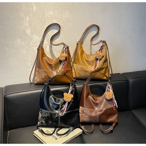 Détail de quatre sacs cabas rétro en cuir PU avec surpiqûres contrastées sur canapé