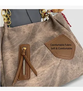 Detail view of brown vintage tote bag showing soft washed fabric texture and gold chain