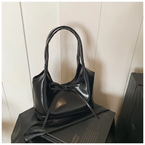Détail d'un sac porté épaule en cuir PU noir avec nœud et doubles poignées longues