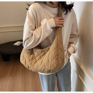 Close-up of large quilted hobo bag with white diamond stitching and wide strap