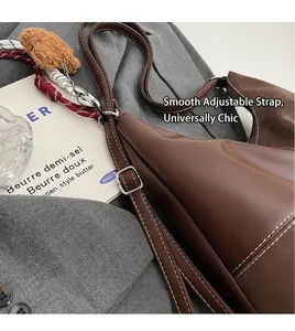 Vue détaillée du sac à bandoulière en cuir marron avec sangle réglable et breloque