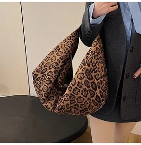 Detail of high-capacity leopard print tote bag styled with a professional grey blazer