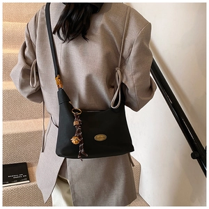 Détail d'un sac hobo noir vintage avec plaque dorée handmade et pendentif décoratif