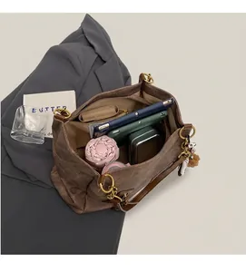 Macro view of interior compartments in dark brown tote bag showing large storage capacity