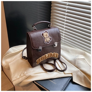 Detailed shot of retro brown leather backpack with bear patch and Holiday embroidery