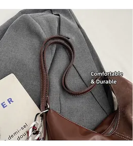 Détail du sac cabas en cuir marron foncé avec surpiqûres blanches et poignées solides