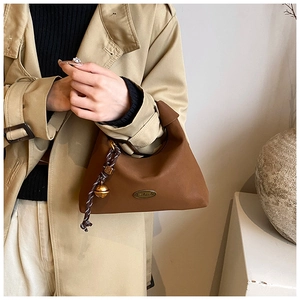 Détail du sac hobo marron mat avec plaque métallique faite main et breloque cloche