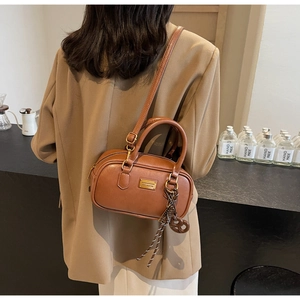 Detailansicht der braunen Retro Boston Tasche mit goldenen Beschlägen und Lederstruktur