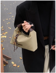 Détail du sac à main vert olive avec poignée marron et plaque en métal fait main