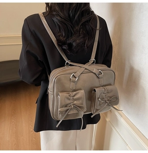 Detail of grey-brown leather backpack with ribbon pockets shown on a model