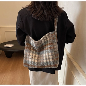 Modelweergave van de grote geruite tote bag in blauw en bruin tweed voor de winter