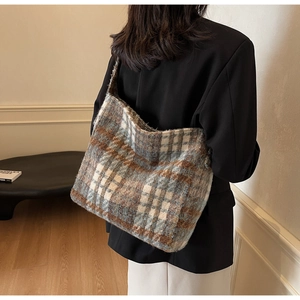 Detail van blauw-bruine geruite tweed shopper met stoftextuur op een vrouwelijk model