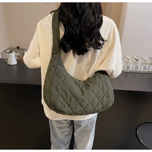 Close-up of quilted military green hobo bag featuring large diamond stitching and wide strap