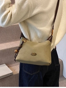 Sac à bandoulière vert olive pour femme avec lanière en cuir dans un décor quotidien