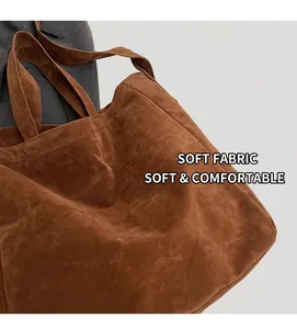 Close-up of the soft brown faux suede texture and wide strap of the large tote bag