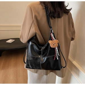 Détail du sac cabas noir avec surpiqûres blanches et charmant pendentif ours marron