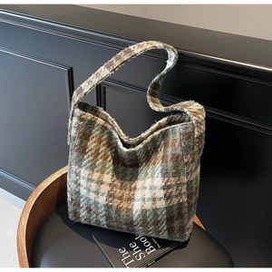 Detail van een groen-bruine geruite tweed shopper geplaatst op een zwarte ronde stoel