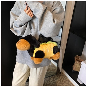 Detailed shot of dachshund plush bag with adjustable black strap worn by a model