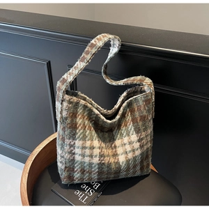 Detailopname van de hoogwaardige tweed stoftextuur van een grote geruite shopper tas