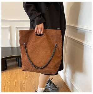 Detail of vintage brown corduroy tote bag with black woven rope strap and thick texture