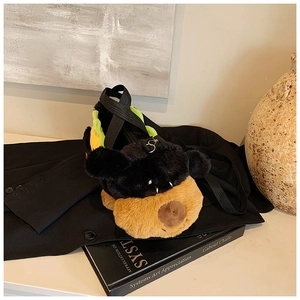 Detail of plush dog crossbody bag with distinct black and brown facial features