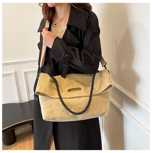 Corduroy tote bag in beige featuring black woven handles and a wide adjustable shoulder strap
