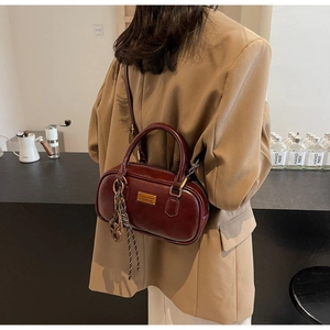 Dunkelrote Vintage-Zylindertasche mit poliertem Finish und goldenen Akzenten