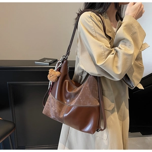 Détail du grand sac cabas en cuir avec coutures contrastées et breloque ours en peluche