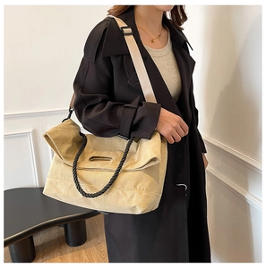 Detail of corduroy tote bag with rope handles and adjustable shoulder strap on model