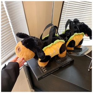 Detailed plush dog crossbody bag in taco shell outfit displayed on art books