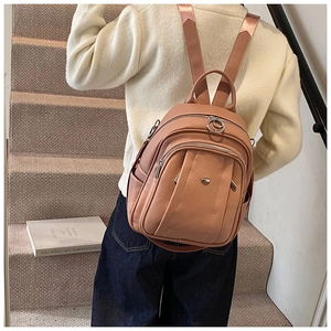 Rückansicht eines Modells mit einem hellbraunen Lederrucksack mit Metallreißverschlüssen