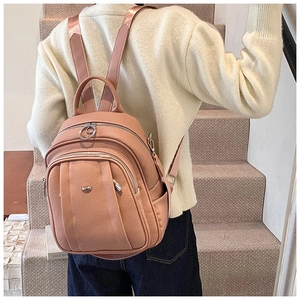 Rückansicht von rosa Kunstleder-Rucksack mit silbernen Zippern auf Freizeitoutfit