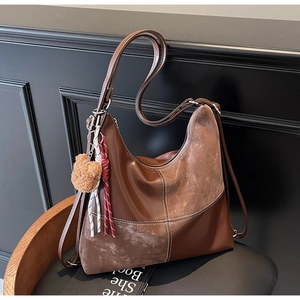Détail du sac cabas marron foncé avec surpiqûres blanches et pendentif ours doux