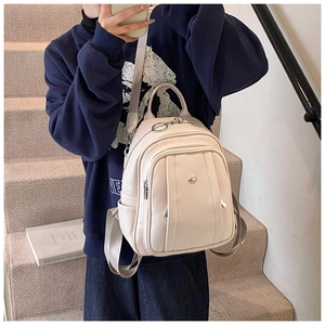 Nahaufnahme des cremeweißen Rucksacks aus Kunstleder mit Lychee-Maserung und Metall-Zippern