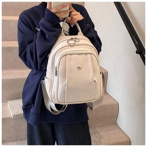 Detail eines stilvollen elfenbeinfarbenen Rucksacks aus Leder, leger in der Hand gehalten