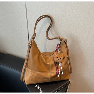 Détail du sac hobo caramel avec patchwork en cuir et pendentif ours en peluche