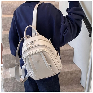 Detail eines stilvollen Lederrucksacks in Creme mit Seitentaschen und Trägern